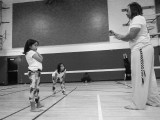 Instrutor Estagiário Âncora teaches twin girls in the art of capoeira.
