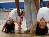 Instrutor Estagiário Âncora assists his students with backbends.